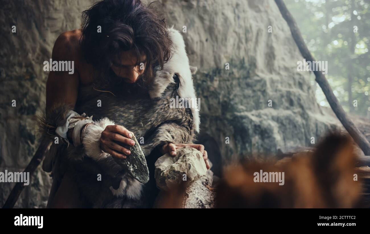 Close-up Shot of a Primeval Caveman Wearing Animal Skin Hits Rock with ...