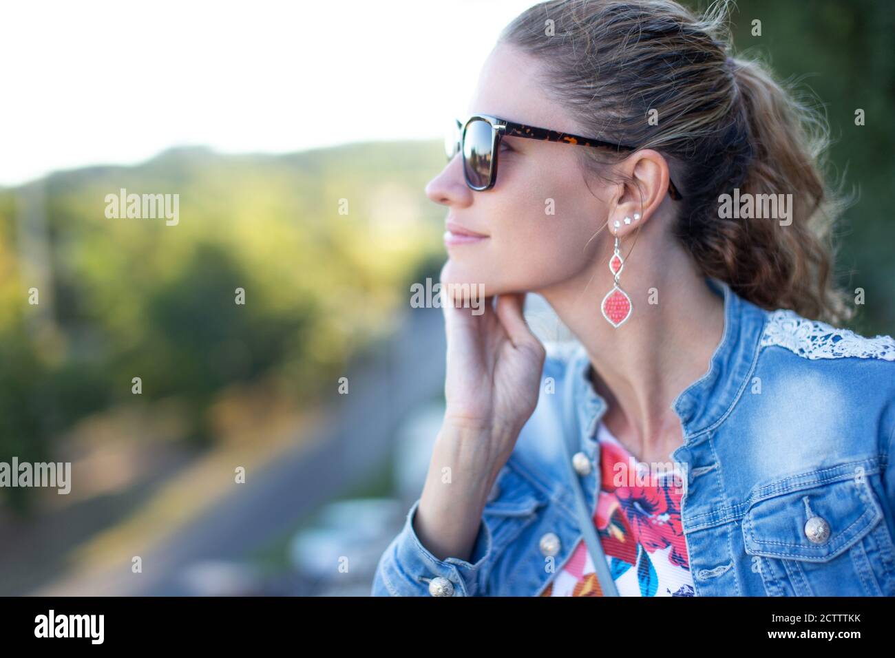 30s Caucasian woman profile view portrait in park looking into distance Stock Photo