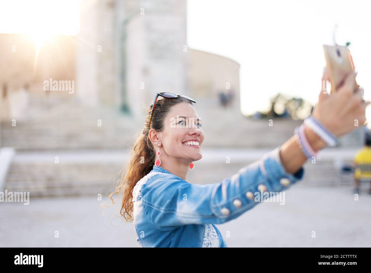 Young urban woman taking selfie at famous place in city Stock Photo