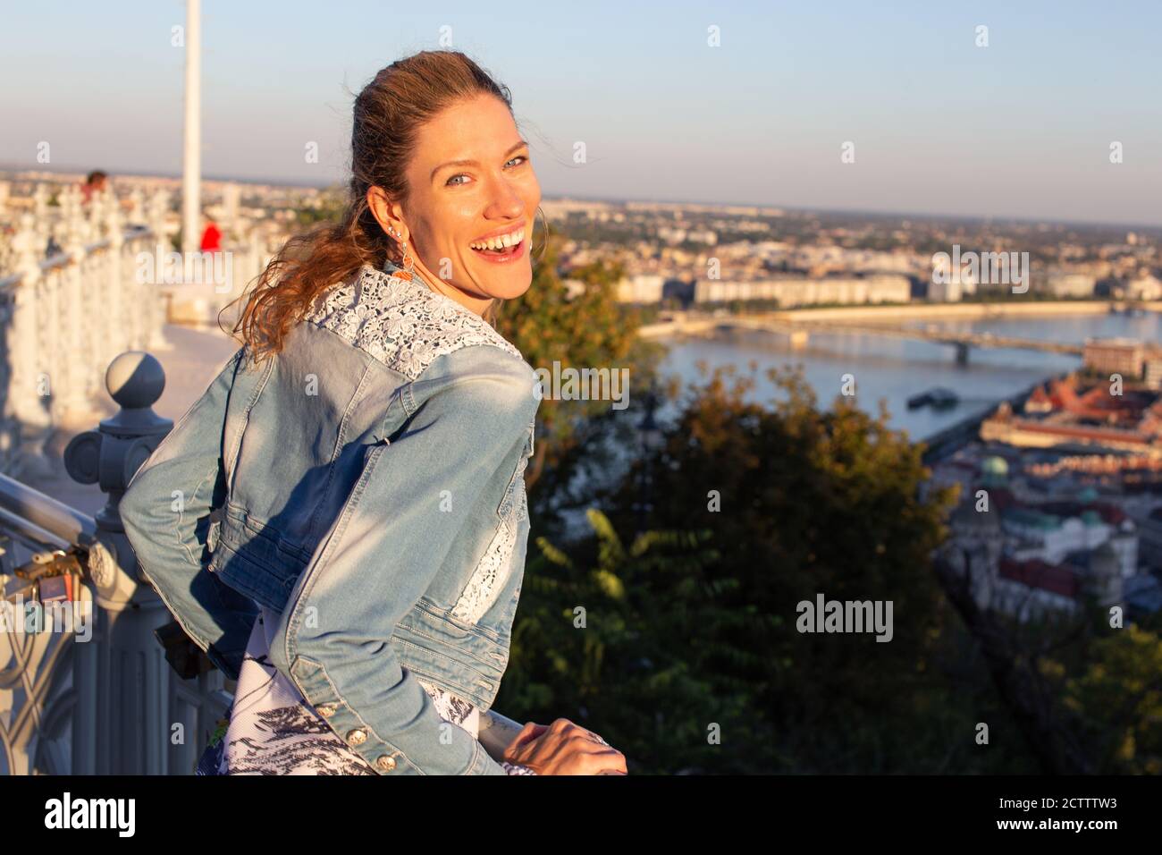 Young carefree urban woman laughing in city sunset Stock Photo
