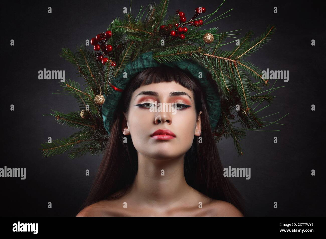 Winter portrait of a young woman with crown of pine branches and red berries Stock Photo