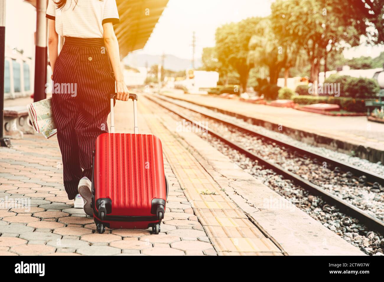 Tourist walking with their luggage in the train station to travel to somewhere for vacation after lockdown. Stock Photo