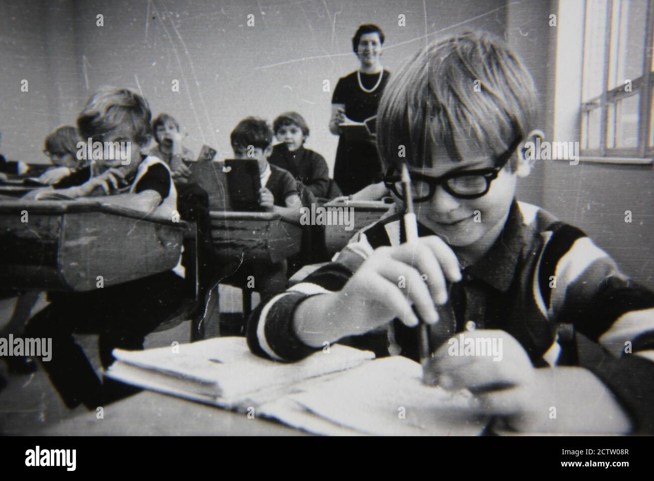 Fine 1970s vintage black and white photography of elementary school students siting in their classroom desks learning their lessons. Stock Photo