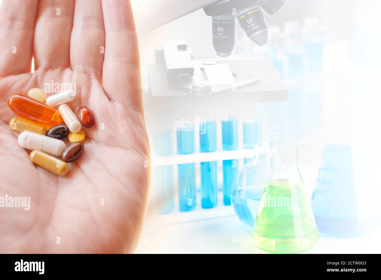 Group of medical pill on hand with science lab medical research on background space for text. Stock Photo