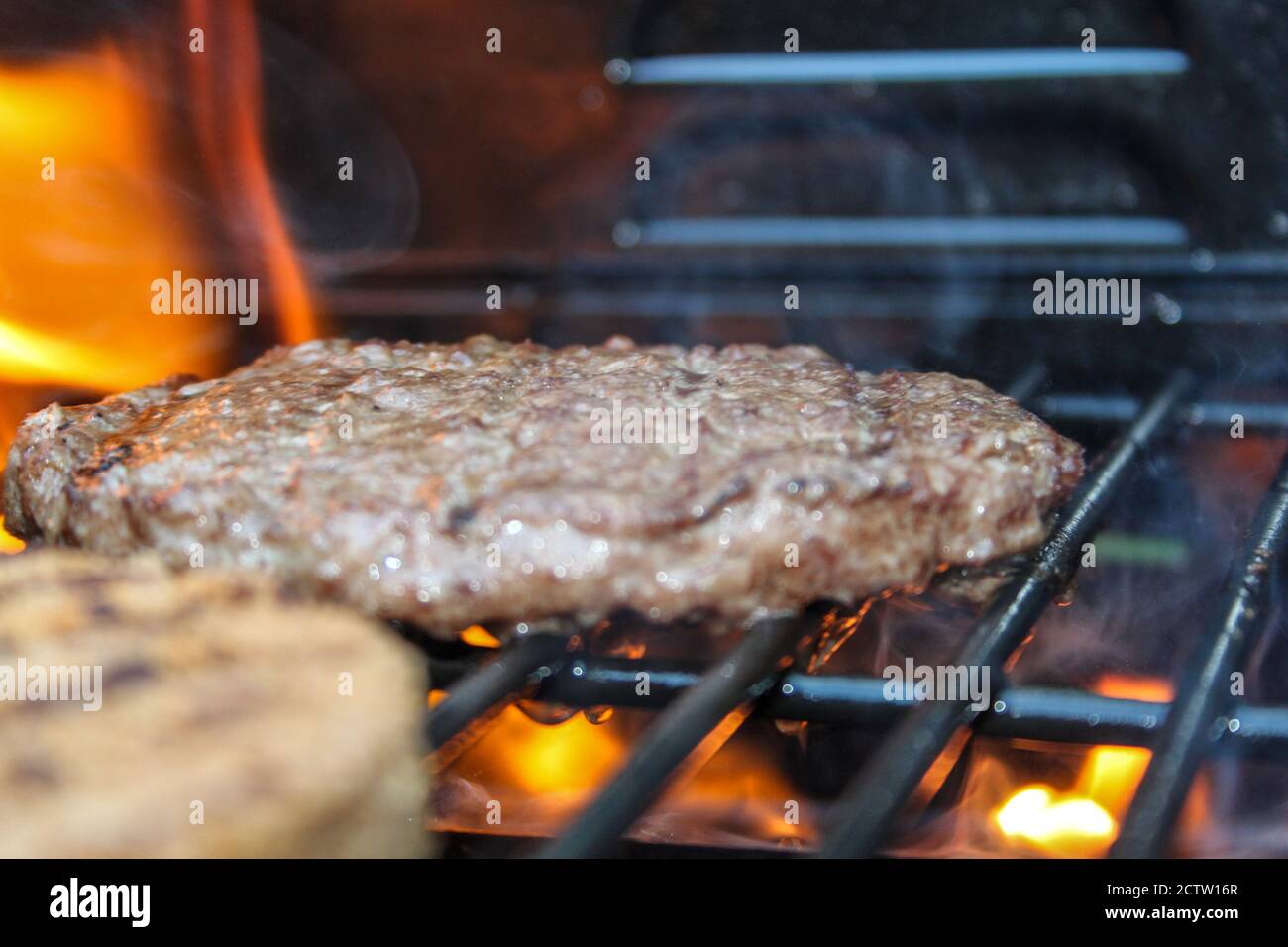 Burger on the Grill with Flames - Flame Grilled BBQ Stock Photo - Alamy