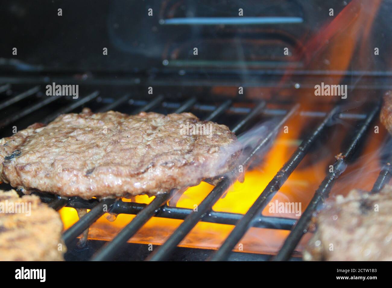 Burger on the Grill with Flames - Flame Grilled BBQ Stock Photo - Alamy