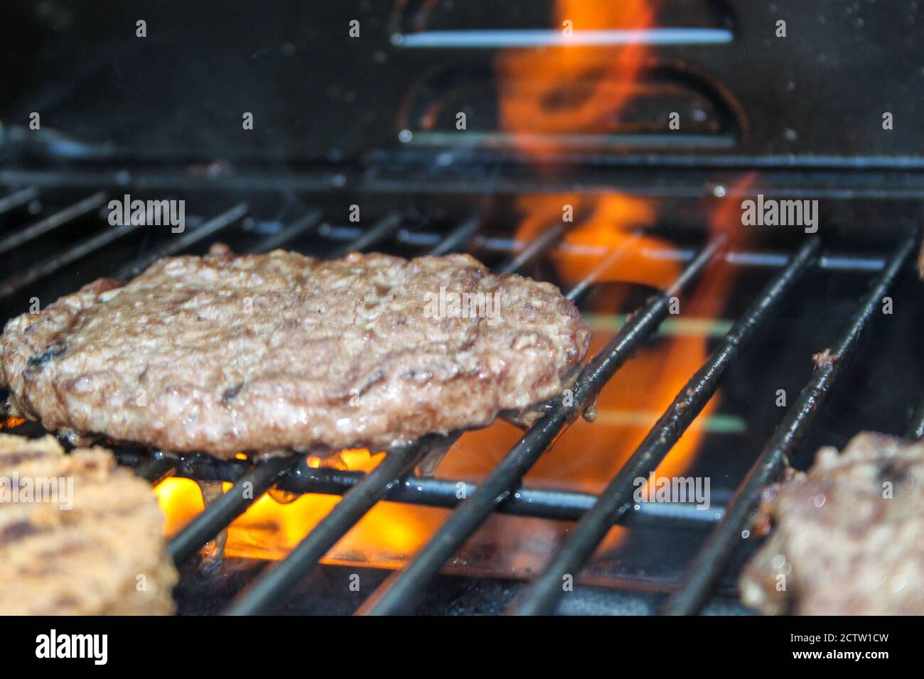 Burger on the Grill with Flames - Flame Grilled BBQ Stock Photo - Alamy