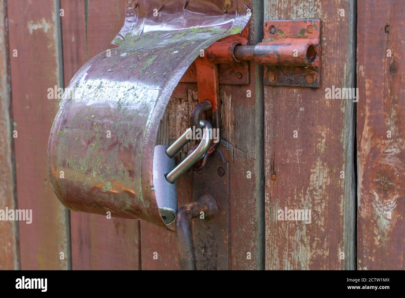 metal lock with rain protection hanging from an old wooden door close up  Stock Photo - Alamy