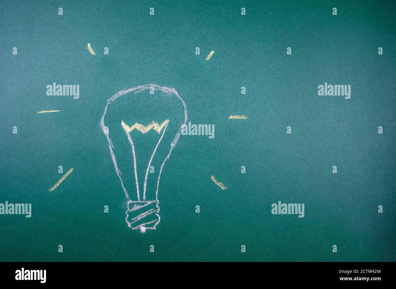Chalk hand-drawn light bulb on a green Board, copy space. concept of ideas, thoughts, light Stock Photo