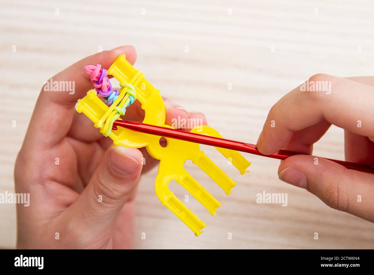 Rubber Band Weaving. Knitting rubber bands with loom knit. Hands of