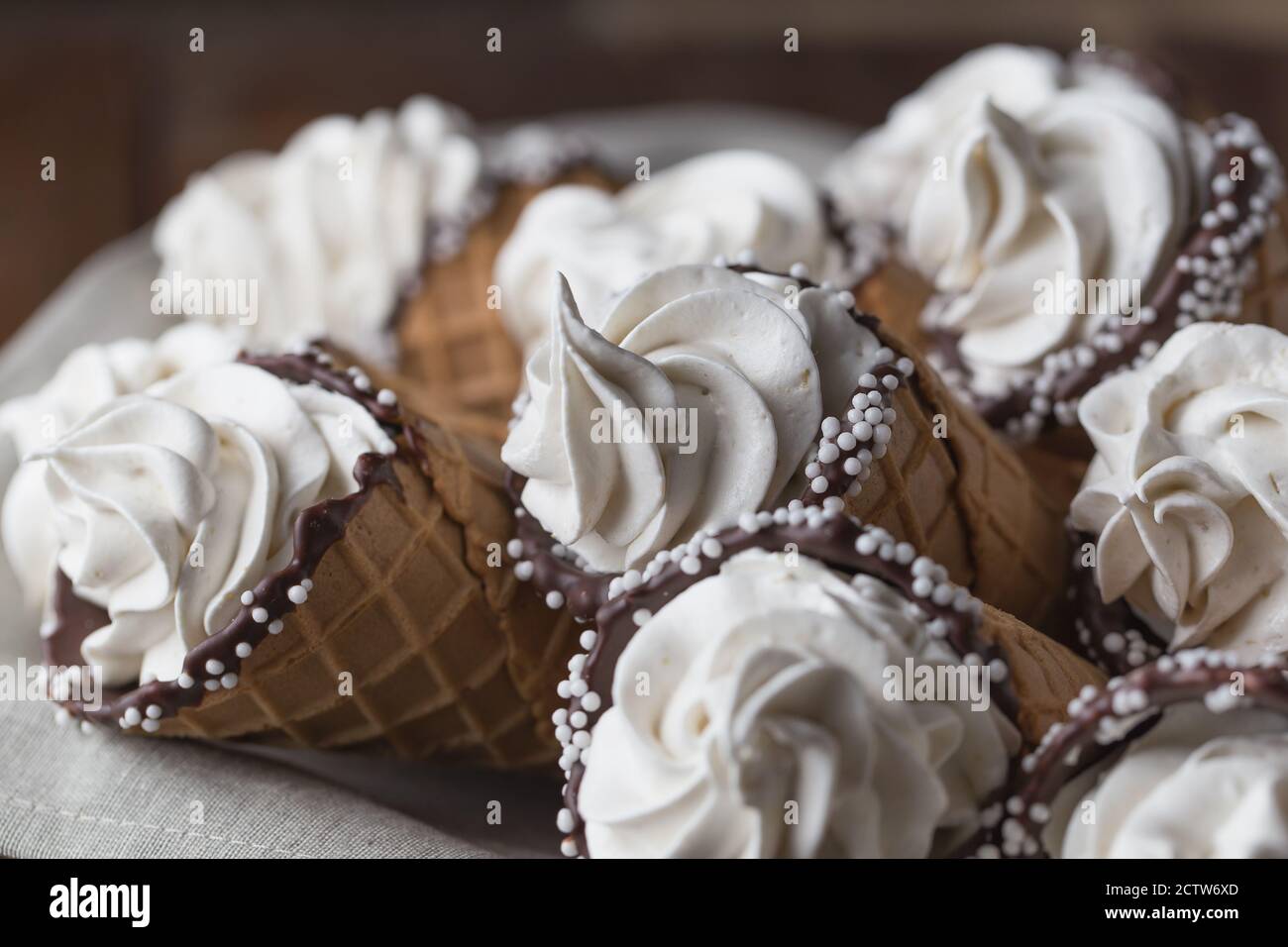 A lot of ice cream cones on wooden table. Soft ice creams or frozen