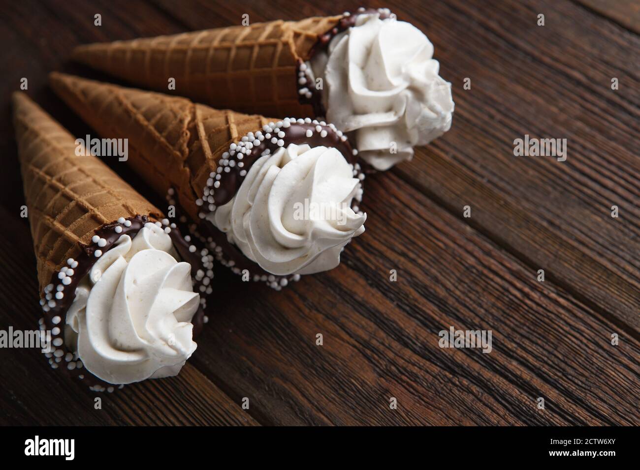 ice cream cones on wooden table. Soft ice creams or frozen custard in cones. Waffle marshmallow imitating ice cream Stock Photo