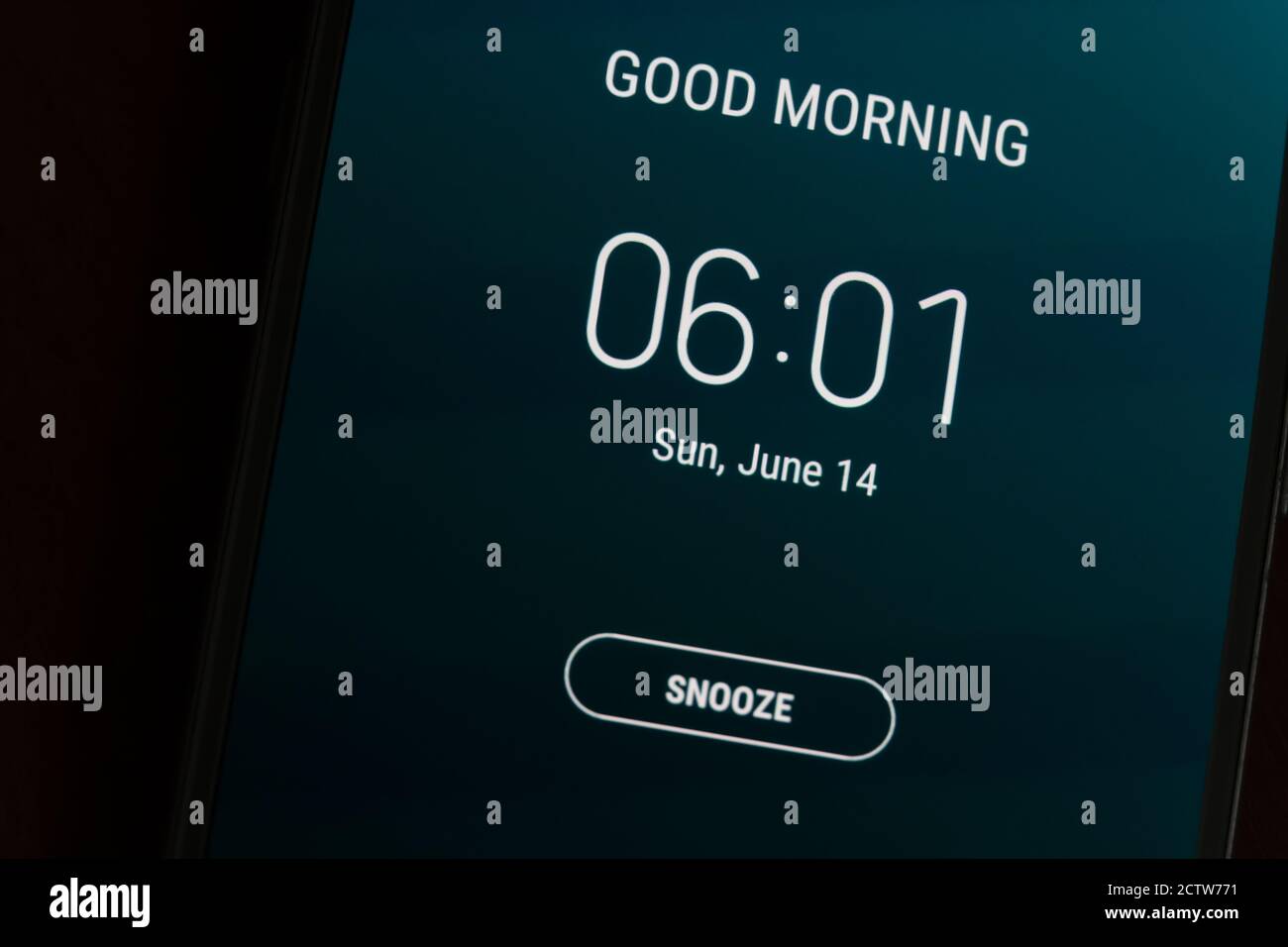 On a black smartphone, an alarm clock rings for 6 am with the