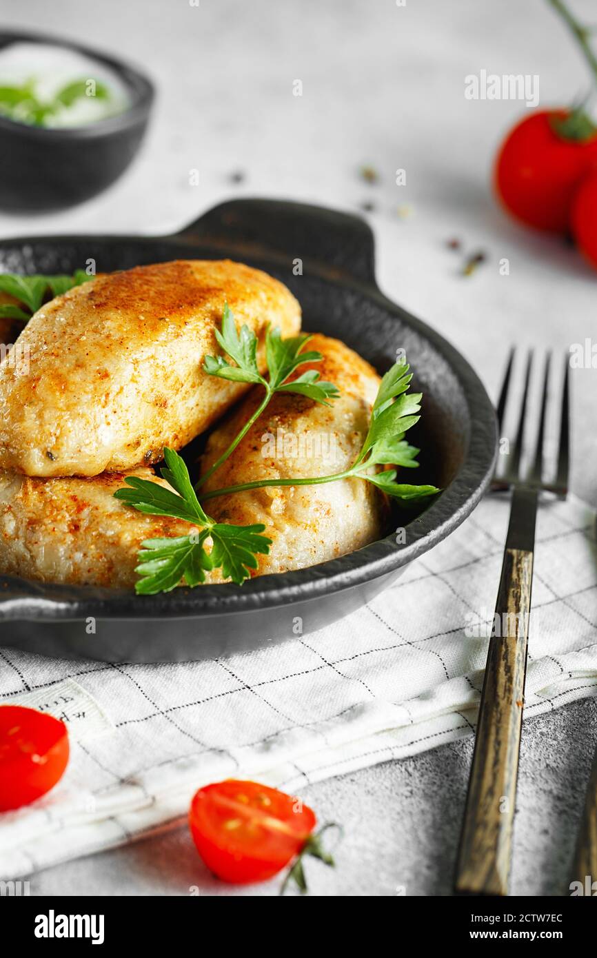 Delicious grilled beef or chicken meatballs. Meat or fish patties on the little frying pan served with parsley and tomatoes. Food photography. Stock Photo