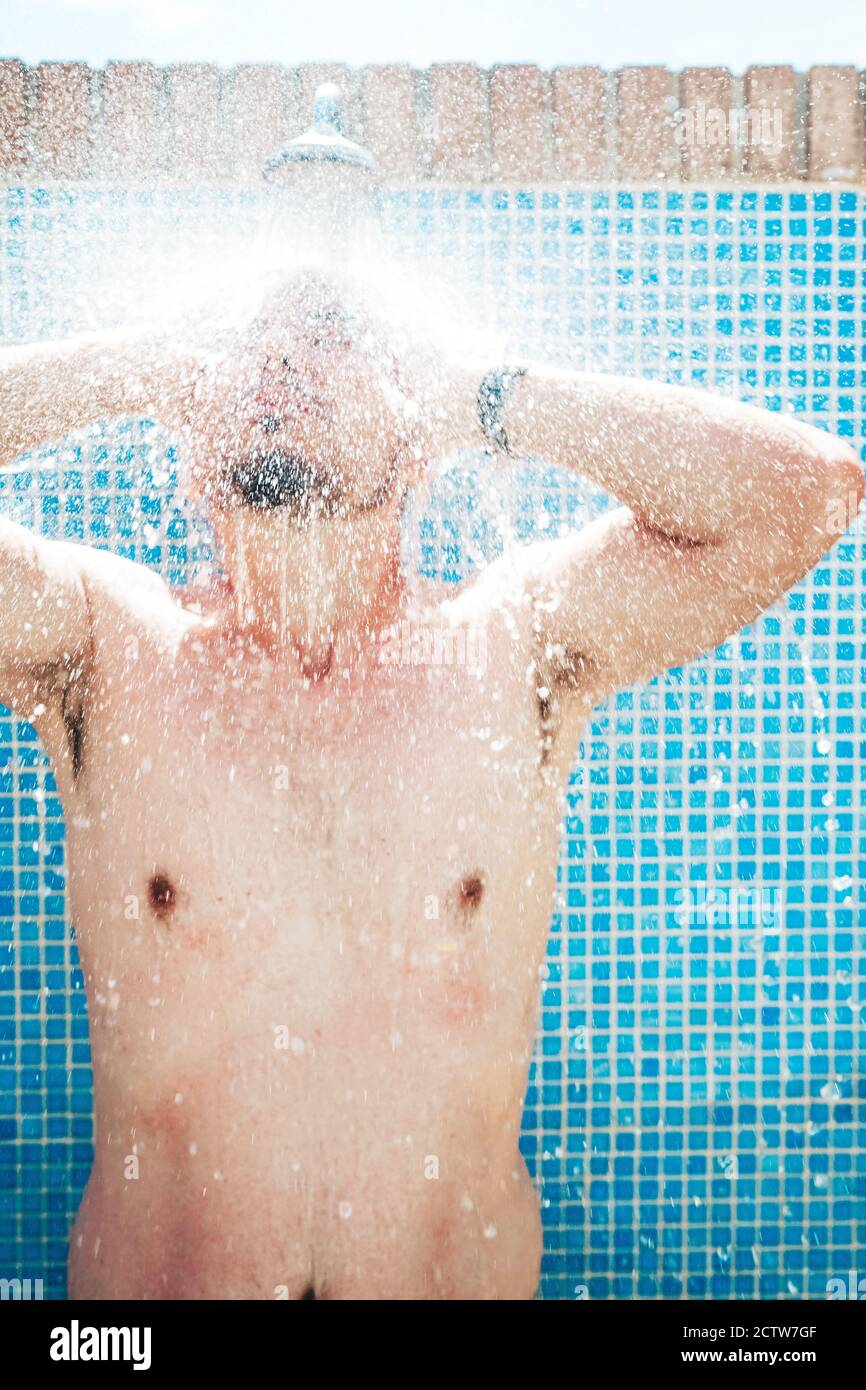 Young man having a shower before pool Stock Photo Alamy