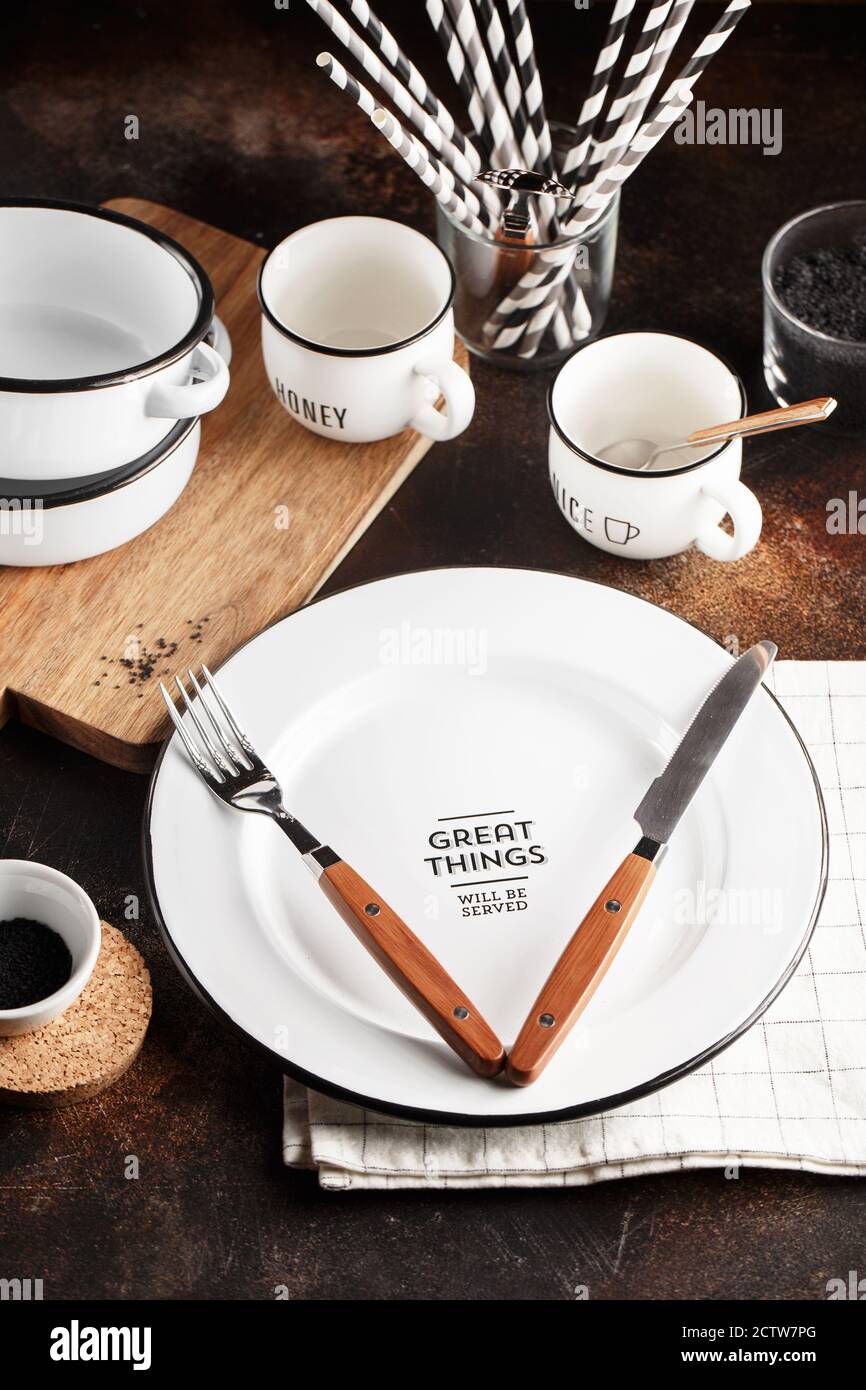 Crockery and cutlery on a dark background with copy space. White metal