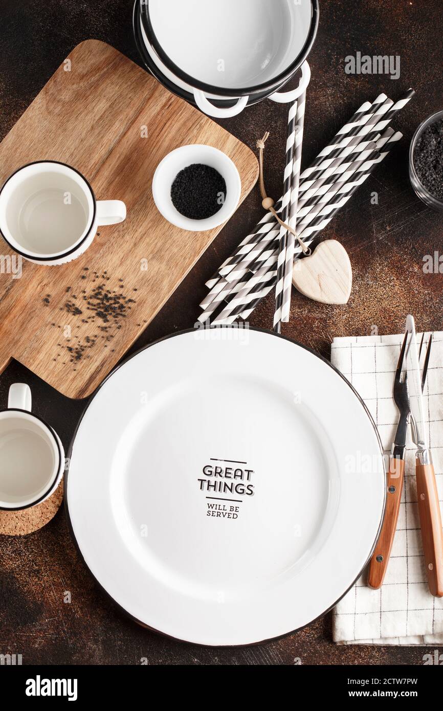 Crockery and cutlery on a dark background with copy space. White metal