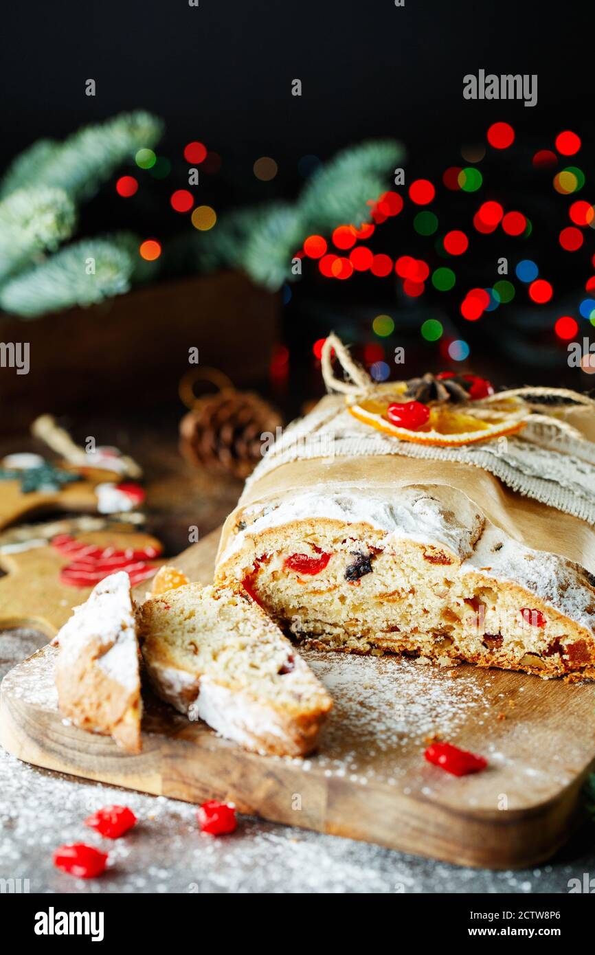 Holiday baking. Christmas cake. Stollen is fruit bread of nuts, spices, dried or candied fruit, coated with powdered sugar. It is traditional German b Stock Photo