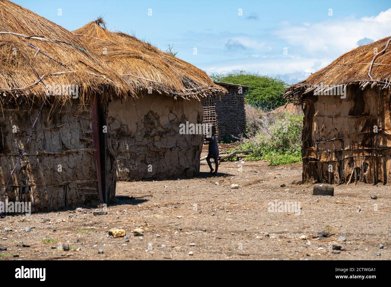 ENGARE SERO. TANZANIA - JANUARY 2020: Indigenous Maasai Boy near the Clay Hut in Traditional Village. Maasailand is the area in Rift Valley Between Stock Photo