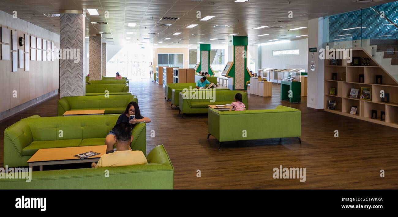 Kota Kinabalu, Sabah, Malaysia: Interior of Sabah Regional Library at Tanjung Aru Plaza. People readying and studying books in the seating corners. Stock Photo