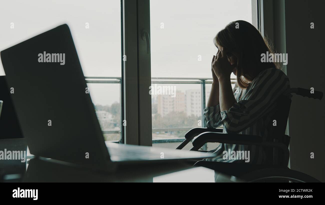 depressed young disabled woman near the window having a headache. High quality photo Stock Photo