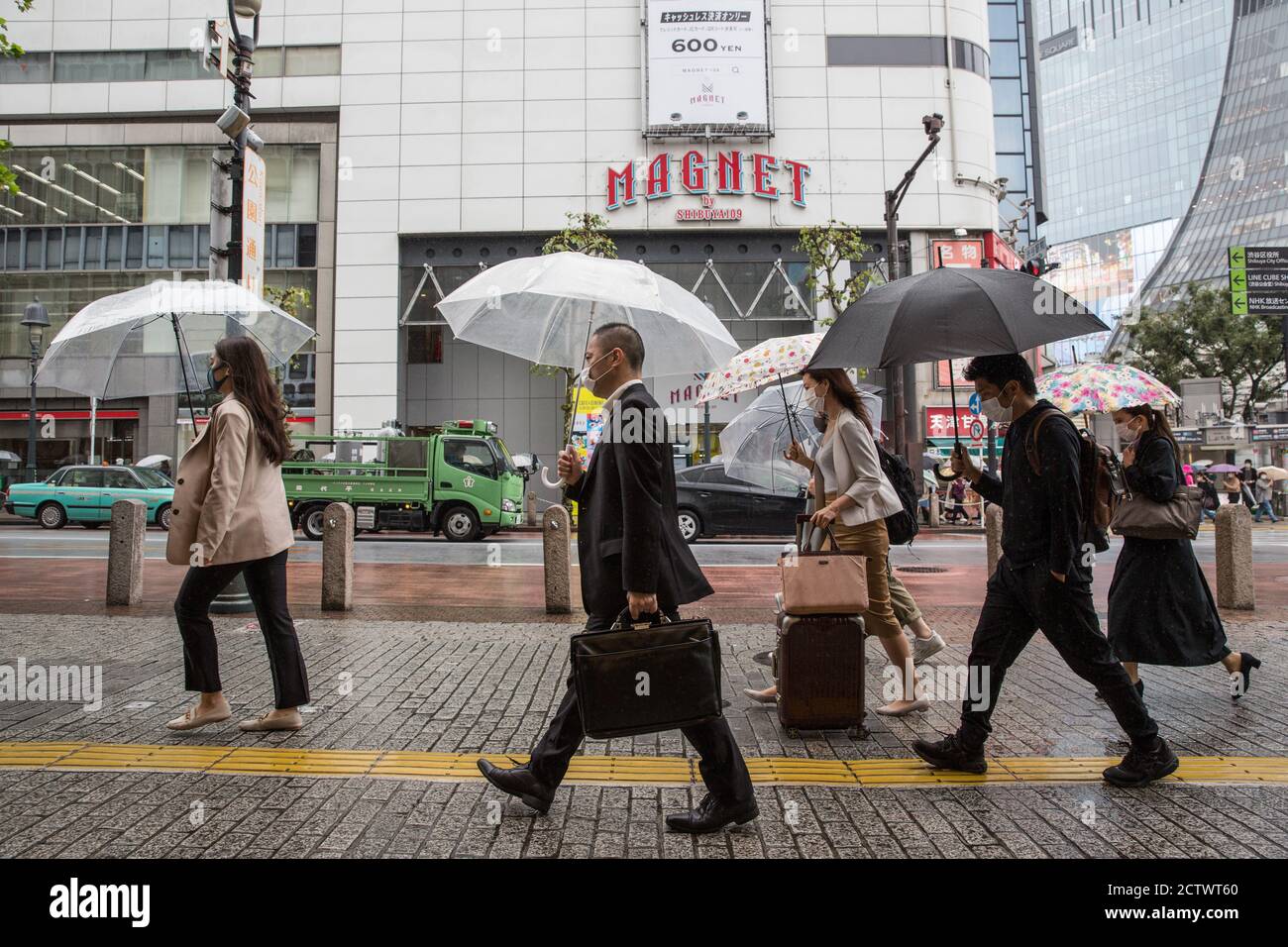 Pedestrians holding umbrellas walk near the Shibuya Crossing during a ...