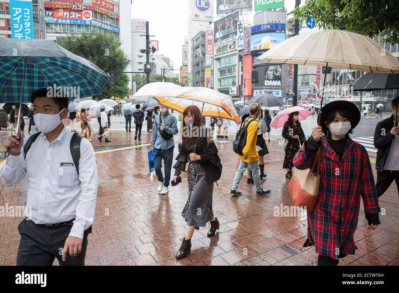 Pedestrians hold umbrellas while walking near the Shibuya Crossing ...