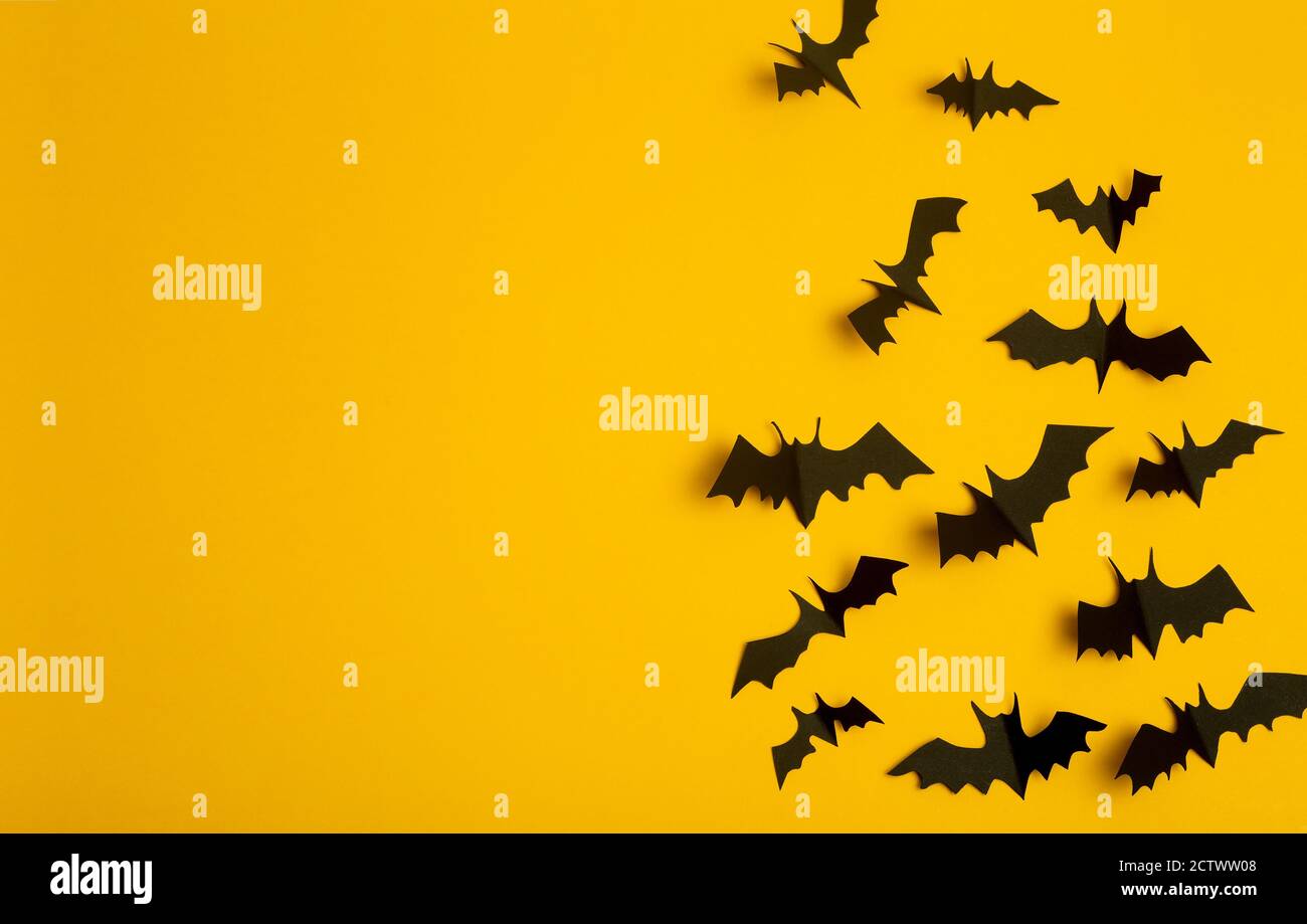 Halloween background. Black bats cut from paper on a yellow background ...