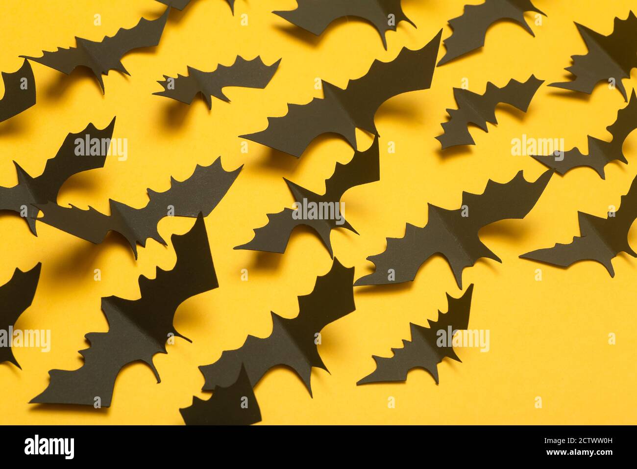 Halloween background. Black bats cut from paper on a yellow background ...