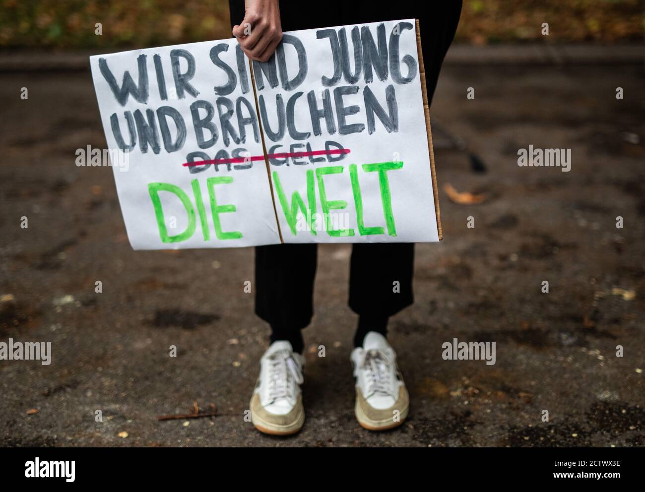 25 September 2020, Baden-Wuerttemberg, Stuttgart: ""We are young and need the world"" is written on the poster of a participant in the global climate strike of the climate protection movement Fridays for Future. The climate movement Fridays for Future has called for a worldwide day of action after months of protests mainly on the internet. Photo: Christoph Schmidt/dpa Stock Photo