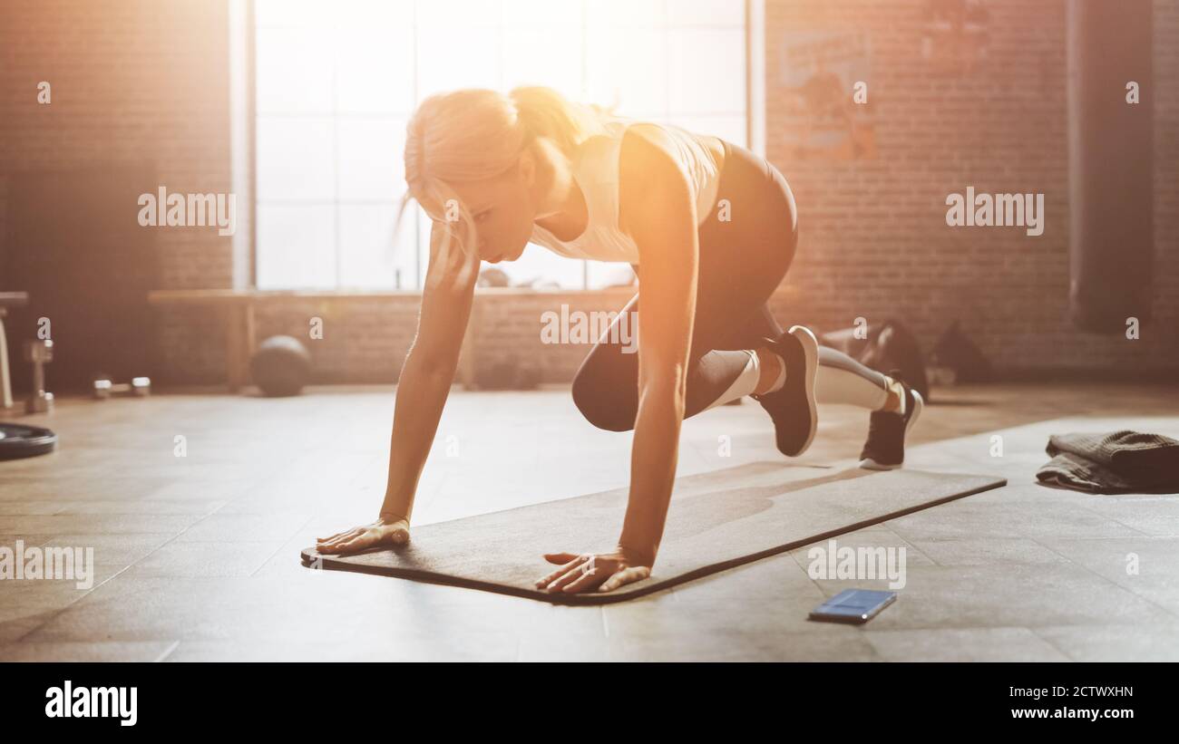 Beautiful and Young Girl Doing Running Plank on Her Fitness Mat. Athletic Woman Does Mountain Climber Workout in Stylish Hardcore Gym. Shot with Warm Stock Photo Alamy