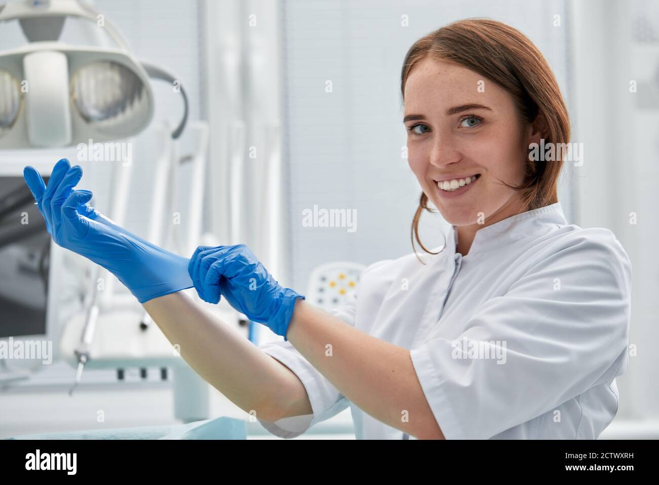 Dentist putting on rubber gloves hires stock photography and images
