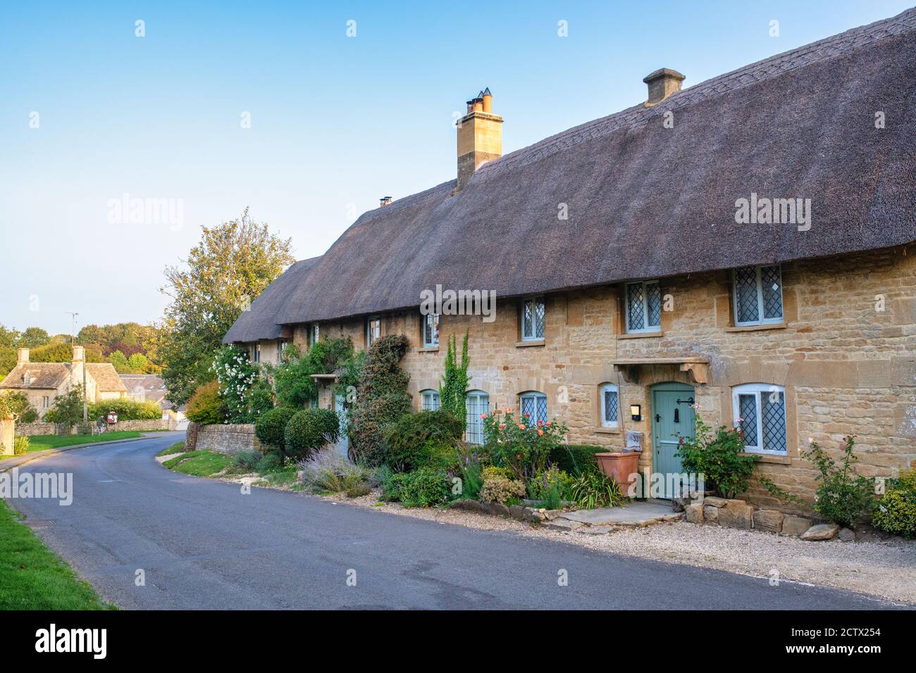 Row of thatched cottages in a cotswold village in early autumn. Taynton, Cotswolds, Oxfordshire