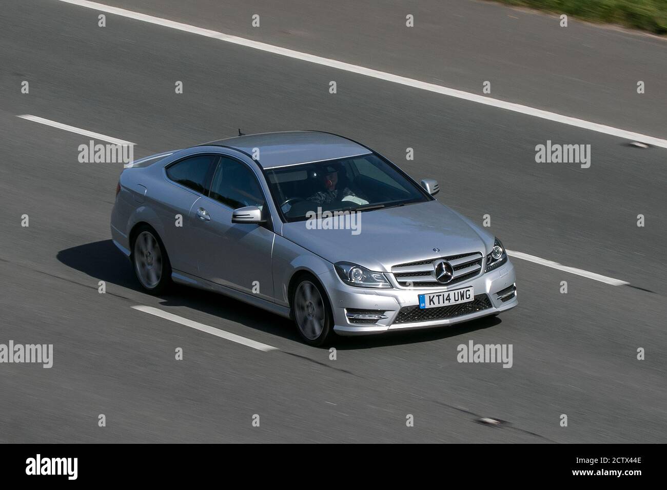 2014 Mercedes-Benz C250 Amg Sport Edt Prem Silver Car Coupe Diesel driving on the M6 motorway near Preston in Lancashire, UK. Stock Photo