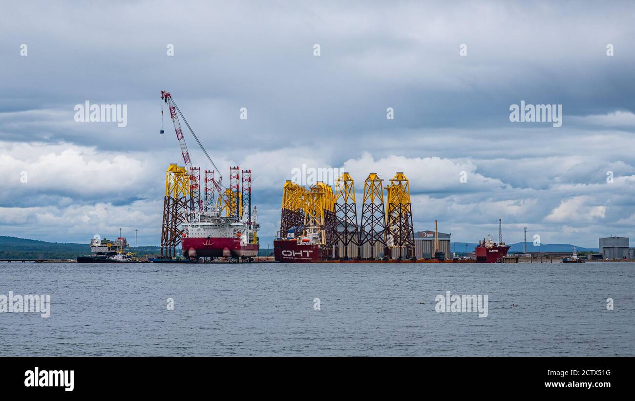 'Seajacks Scylla' is the worlds most advanced offshore wind farm installation vessel. Loading foundation tripods in Cromarty Firth Stock Photo