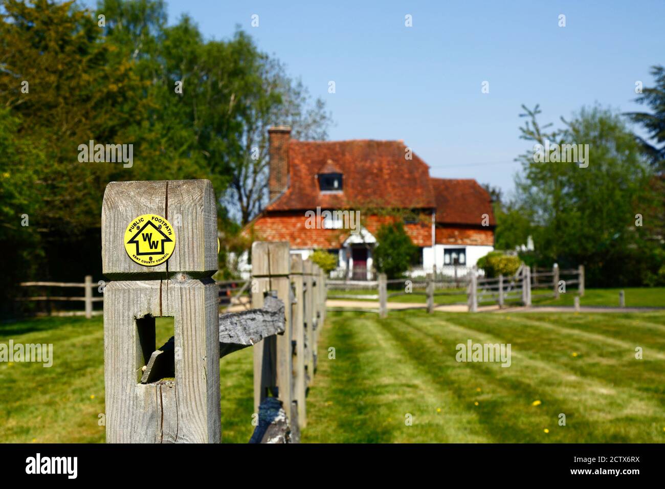 Manor Farm Cottage (a small 17th century farmhouse) and Wealdway long distance footpath sign on fencepost, Lower Haysden, Kent, England Stock Photo