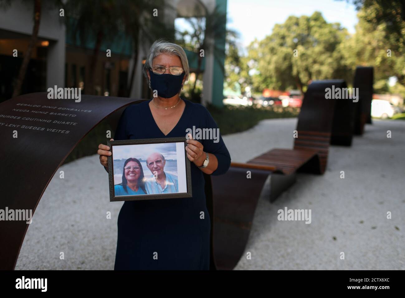Giselle Matuk Diniz Peixoto holds a photo where she is with her father Geraldo Diniz Gonsalves, who died from the coronavirus disease (COVID-19), next to a memorial for covid victims called the Infinity Memorial at the Penitencia cemetery in Rio de Janeiro, Brazil September 24, 2020. Picture taken September 24, 2020. REUTERS/Pilar Olivares Stock Photo