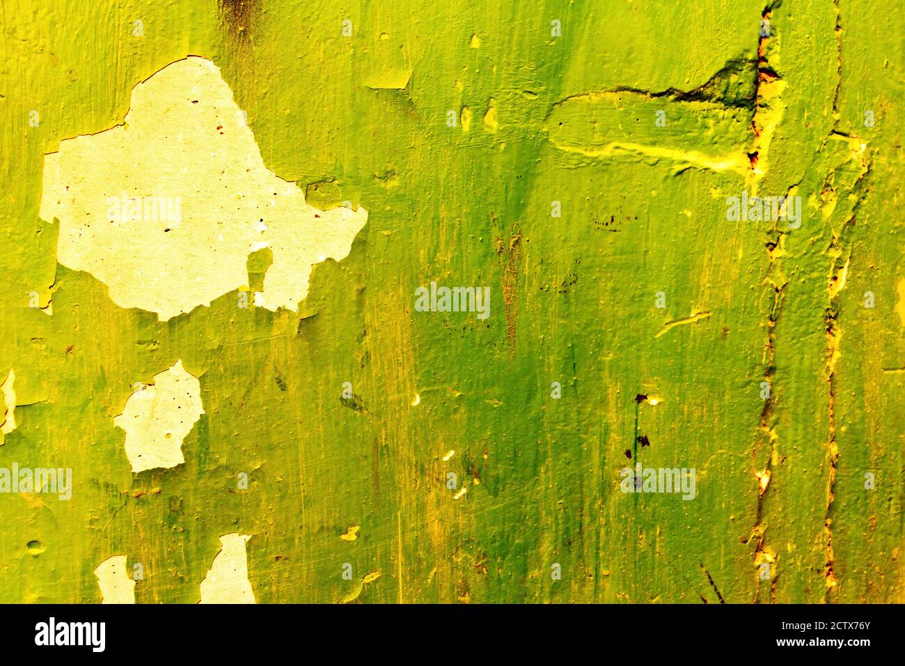 The texture of an old tattered wall with peeling green paint. Stock Photo