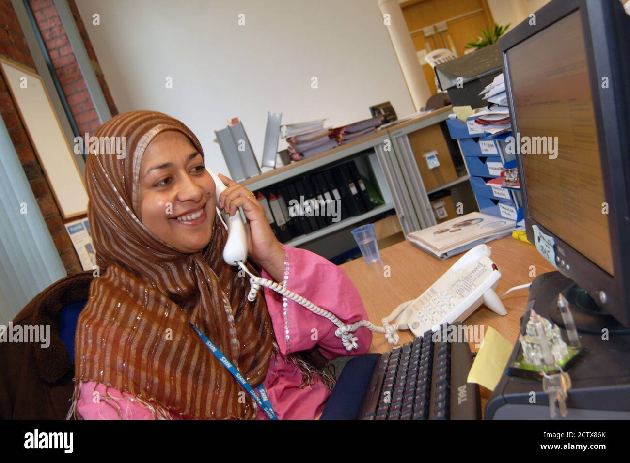 Office worker on the telephone; NHS office UK Stock Photo Alamy