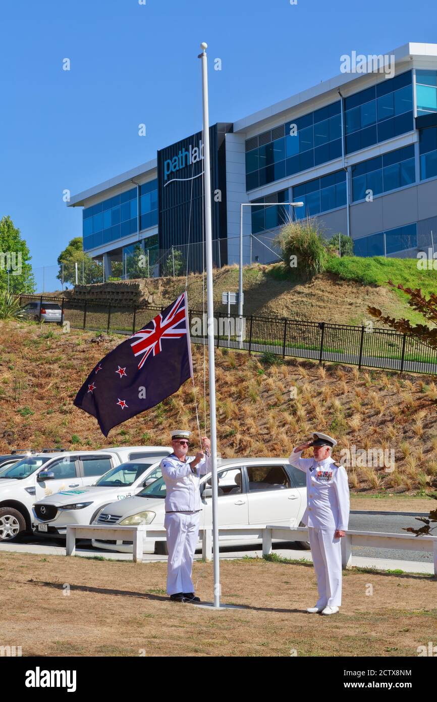 Royal New Zealand Navy personnel ceremonially lowering the flag on Waitangi Day. February 6 2020 Stock Photo