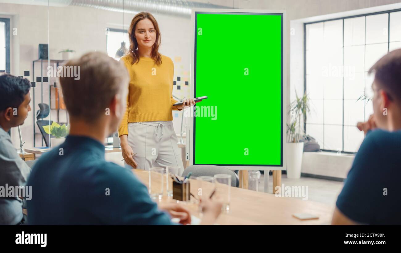 Female Project Manager Holds Meeting Presentation for a Team of Developers. She Shows Green Screen Interactive Whiteboard Device for Business Planning Stock Photo