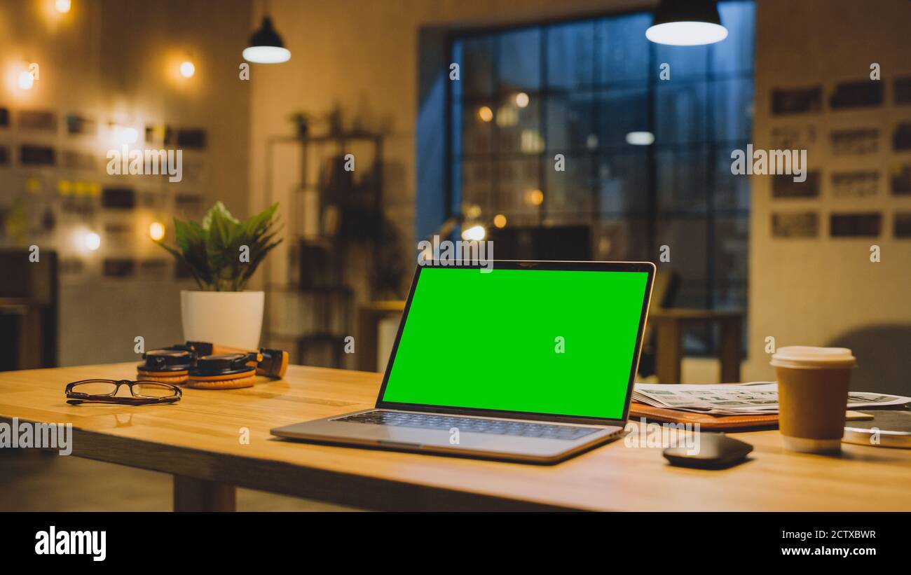 Mock-up Green Screen Stanting on the Desktop. In the Background Stylish  Modern Office Studio in the Evening with Big Cityscape Window Stock Photo -  Alamy