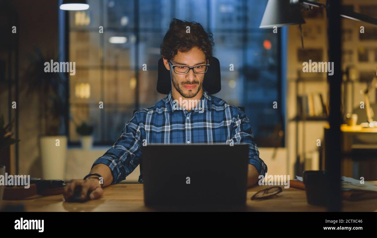 Portrait of the Handsome and Successful Young Creative Entrepreneur Working at His Desk Using Laptop Computer. Working from Cozy Home Office Studio Stock Photo