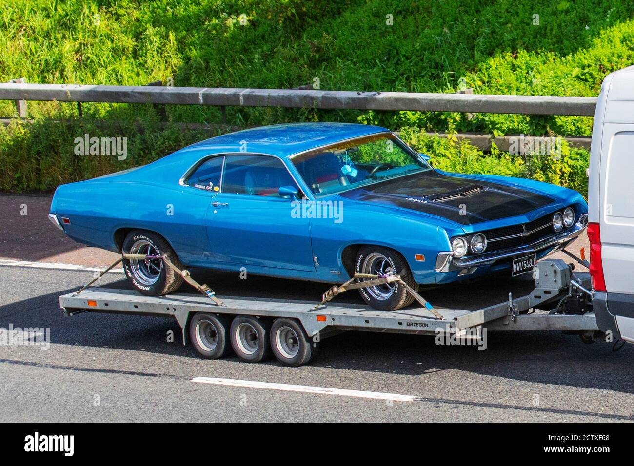 1970 70s blue American Fairlane RamAir 429 on car trailer being towed on the M6 motorway near Manchester, UK Stock Photo