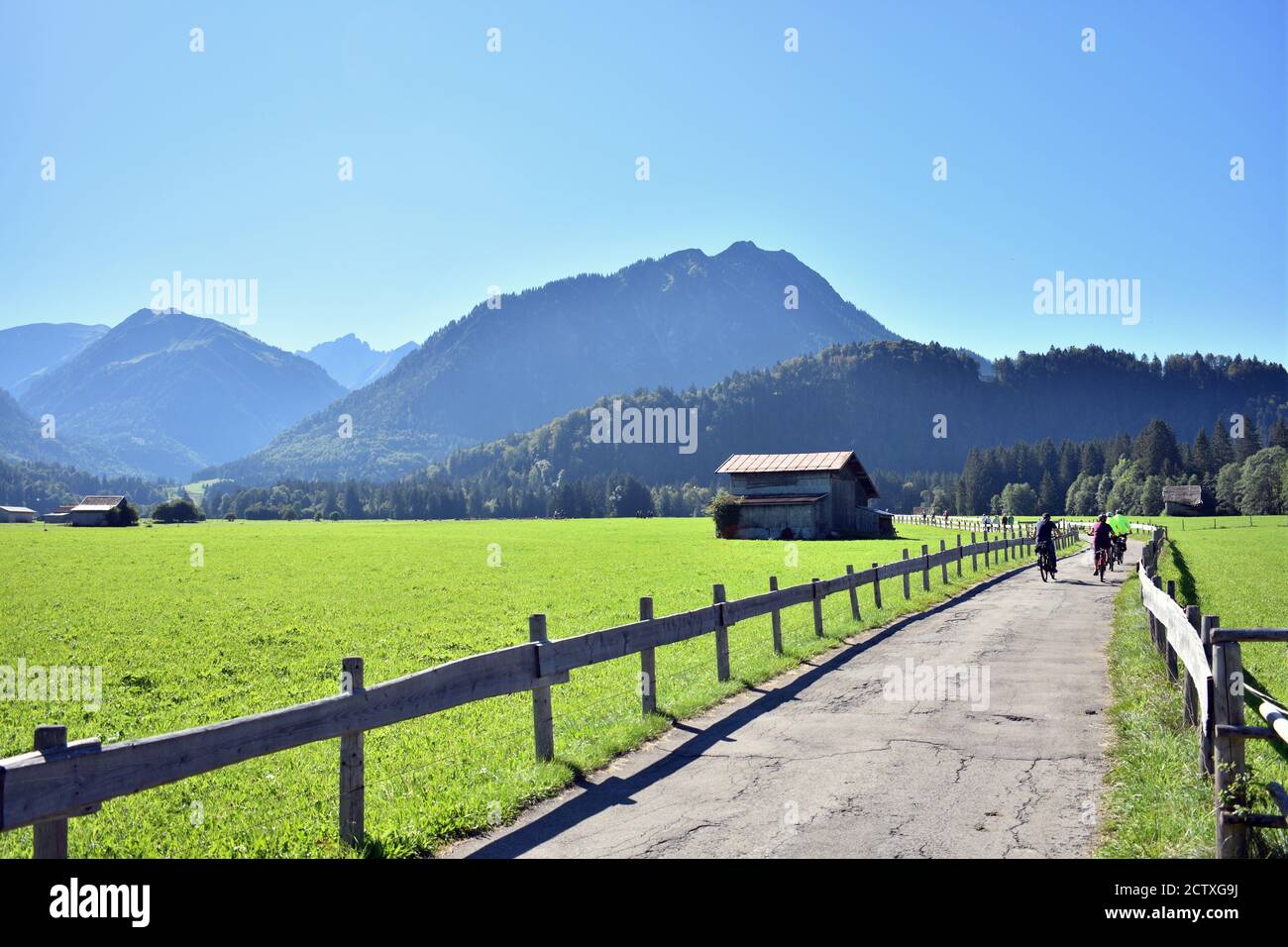 cyclers cycling on Alp mountains in a sunny day ner green field at Oberstdorf Germany Stock Photo