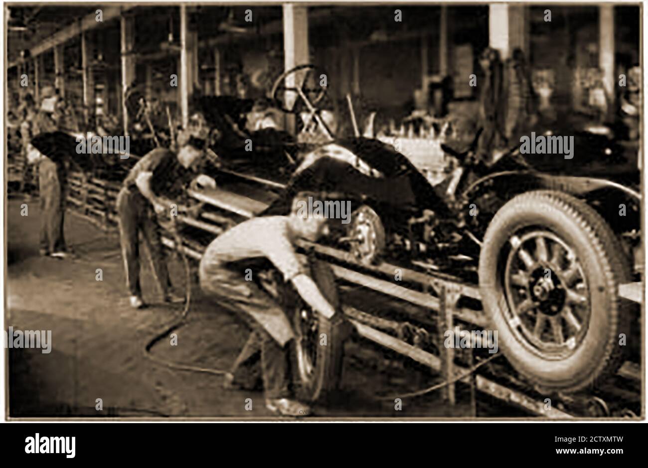 A 1929 printed photo of the chassis assembly line of 'Oloy'  (Oldsmobile?) Motors (USA).The  invention of the assembly line and its basic concepts are credited to Ransom Eli Olds ( 1864 –  1950), who used it to build the first mass-produced automobile, the Oldsmobile Curved Dash Stock Photo