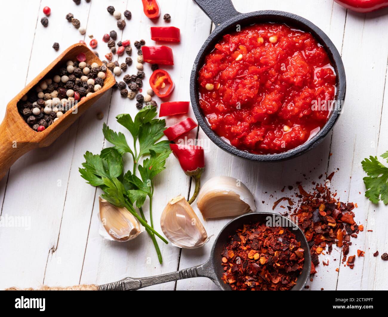homemade red hot sauce pepper ingredients, on a white wooden surface, spices, close up Stock Photo