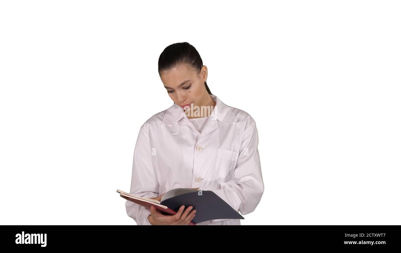 Young doctor woman reading documentation while walking on white Stock Photo