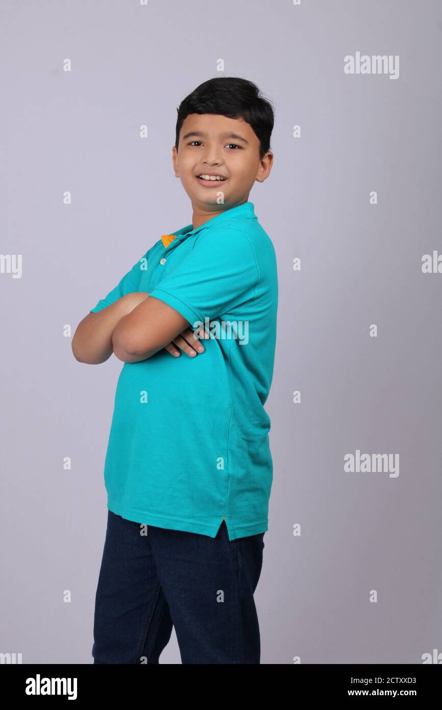smart Indian kid standing with folded hands. Stock Photo