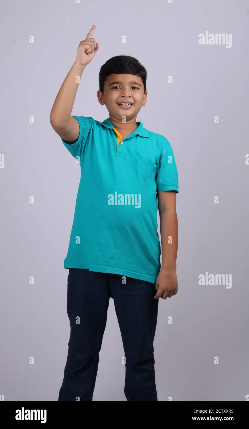 Smiling young boy with his index finger raised. Isolated over white Stock Photo